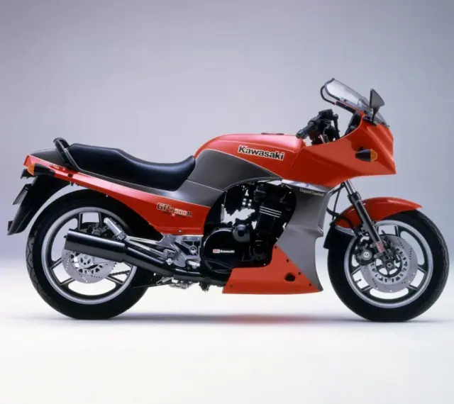 Pomarańczowy motocykl Kawasaki GPZ900R z szarymi akcentami, z lat 80., z owiewką i sportowym wyglądem.