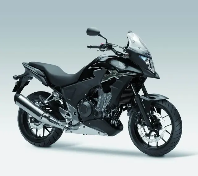 Czarny motocykl Honda CB500X z przyciemnianą szybą i srebrnym wydechem, gotowy na przygodę.