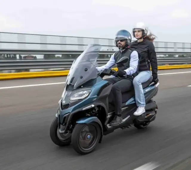 Para jadąca na Piaggio MP3 500, testująca jego prędkość maksymalną na torze wyścigowym.