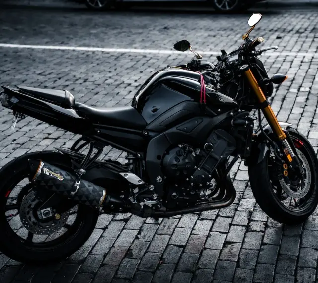 Czarny motocykl na bruku, idealny na giełda motocykli używanych Niemcy. Gotowy do jazdy po niemieckich drogach.