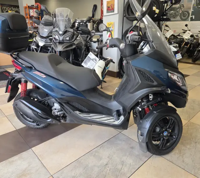 Trójkołowy skuter Piaggio MP3 300 w salonie. Sprawdź piaggio mp3 300 dane techniczne, by poznać jego możliwości.