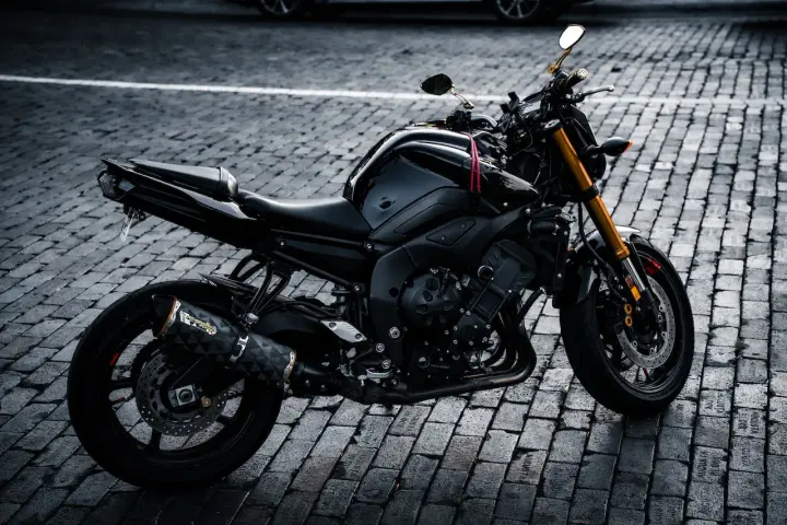 Czarny motocykl na bruku, idealny na giełda motocykli używanych Niemcy. Gotowy do jazdy po niemieckich drogach.