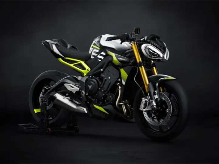 Agresywny Triumph Street Triple w biało-czarnej kolorystyce z neonowo-żółtymi akcentami, zdominowany przez złote lagi i sportowy wygląd.