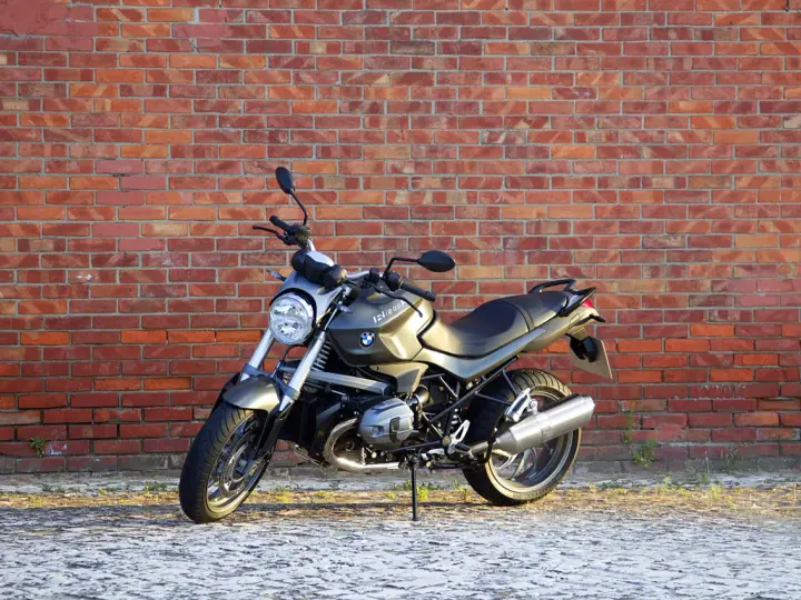 Szary motocykl BMW R1200R na tle ceglanej ściany. Poznaj jego dane techniczne i możliwości.