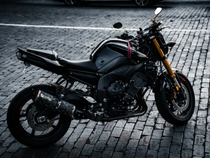 Czarny motocykl na bruku, idealny na giełda motocykli używanych Niemcy. Gotowy do jazdy po niemieckich drogach.