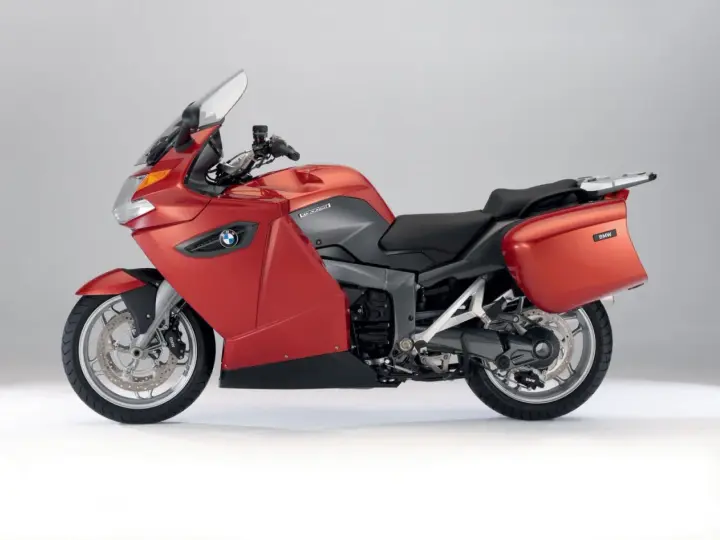 Czerwony motocykl turystyczny BMW K1300GT z kuframi, gotowy na długie podróże.