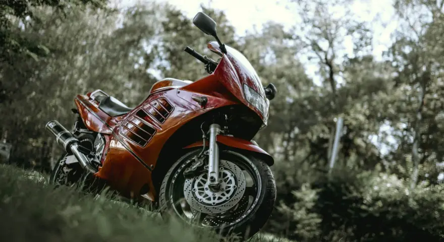 Czerwony motocykl Suzuki RF 900 na trawie. Warto sprawdzić suzuki rf 900 dane techniczne przed zakupem.