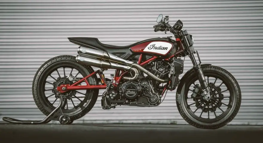 Stylowy Indian FTR 1200 w kolorze czerwono-białym, z podwójnym wydechem i czarnymi felgami, gotowy do jazdy.