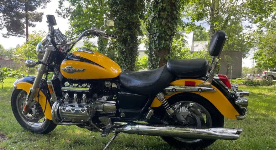 Żółta Honda Valkyrie 1500, z chromowanymi elementami i potężnym silnikiem, zaparkowana na trawie. Dane techniczne tego klasyka budzą podziw.