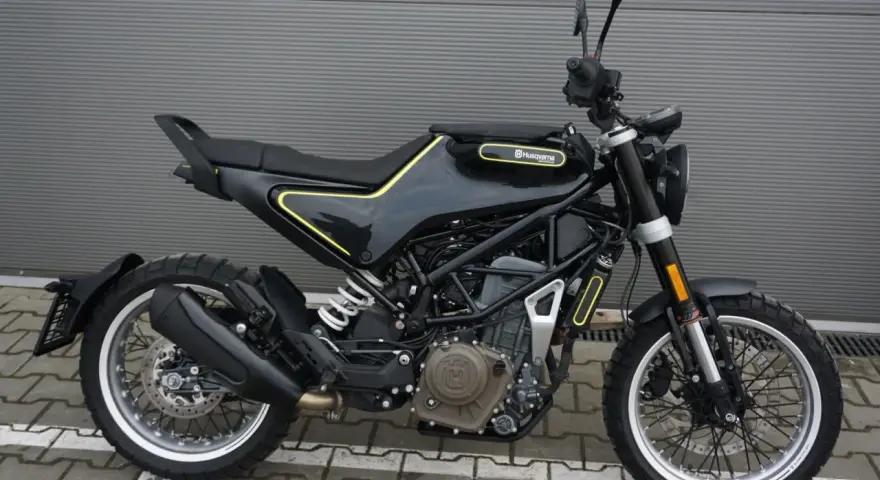 Czarny motocykl Husqvarna Svartpilen 401 z żółtymi akcentami, gotowy na miejskie przygody.