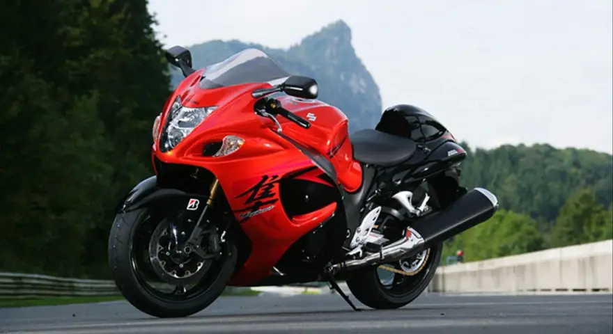 Czerwony motocykl Suzuki Hayabusa na drodze, z widokiem na góry. Poznaj jego suzuki hayabusa dane techniczne.