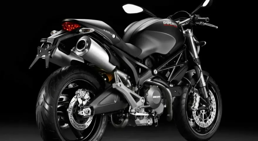 Czarny Ducati Monster 696 z podwójnym wydechem i sportowym wyglądem, gotowy do jazdy.