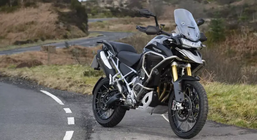 Czarny motocykl Triumph Tiger 1200 na tle krajobrazu. Poznaj jego imponujące triumph tiger 1200 dane techniczne.