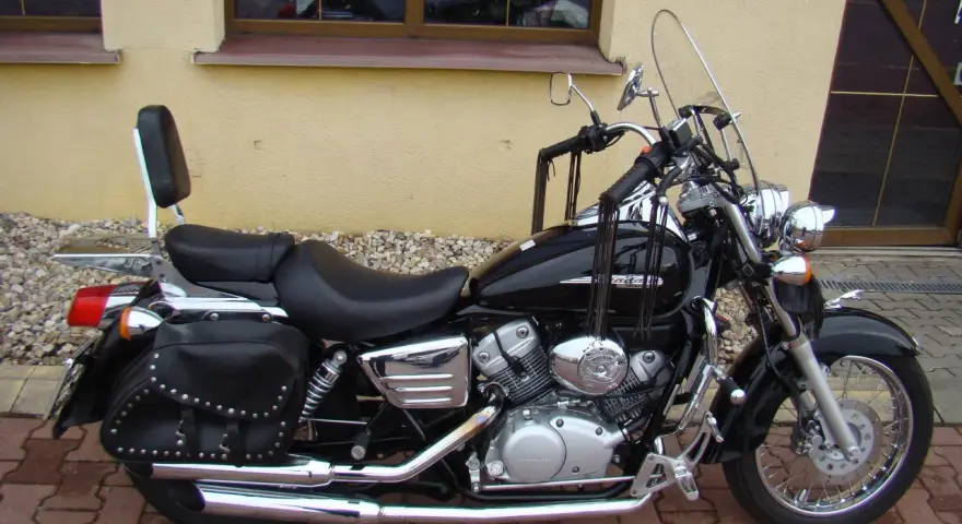 Czarny motocykl Honda Shadow 125, z sakwami i oparciem. Idealny na podróże, poznaj jego honda shadow 125 dane techniczne.