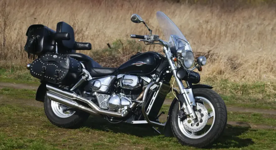 Czarny Suzuki Marauder z sakwami i oparciem, gotowy na podróż przez jesienne krajobrazy.