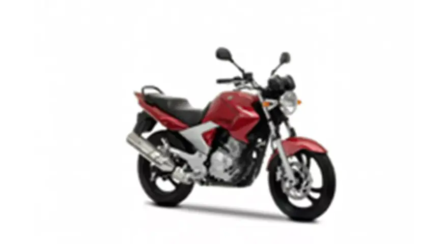 Czerwony motocykl Yamaha YBR 250 z czarnym siedzeniem i srebrnym wydechem, gotowy do jazdy po mieście.