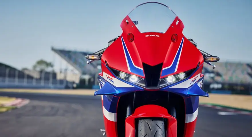 Czerwono-niebieski motocykl Honda CBR 600RR na torze wyścigowym. Poznaj honda cbr 600rr dane techniczne i poczuj moc!