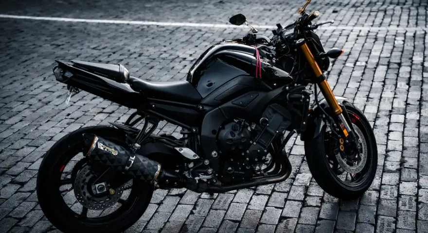 Czarny motocykl na bruku, idealny na giełda motocykli używanych Niemcy. Gotowy do jazdy po niemieckich drogach.