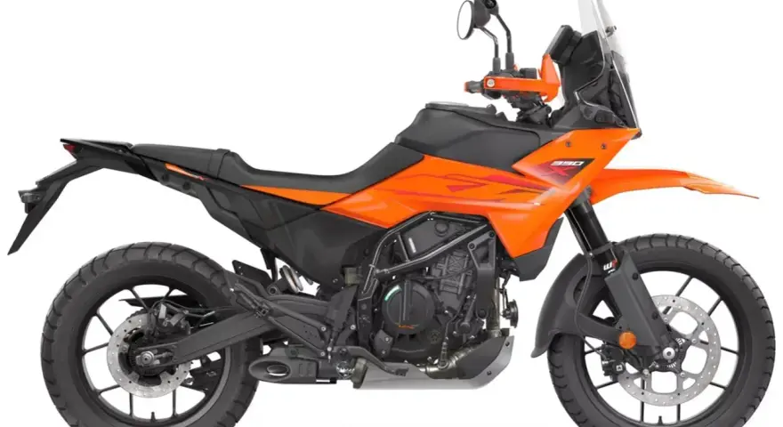 Pomarańczowy motocykl KTM 390 Adventure gotowy na przygodę.