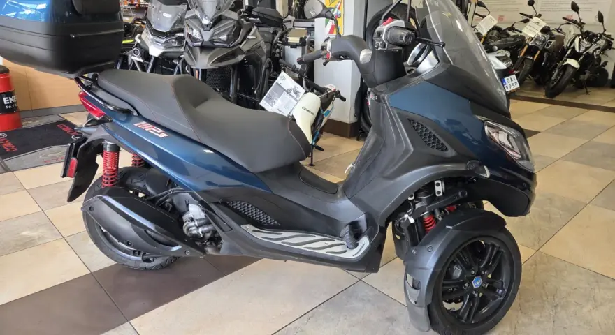 Trójkołowy skuter Piaggio MP3 300 w salonie. Sprawdź piaggio mp3 300 dane techniczne, by poznać jego możliwości.
