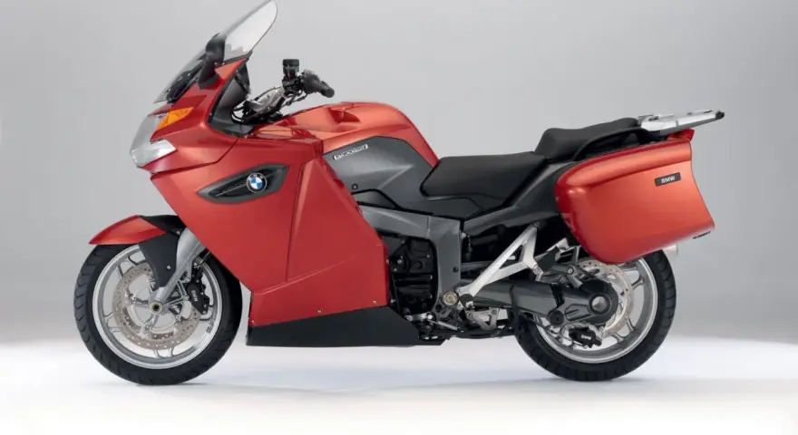 Czerwony motocykl turystyczny BMW K1300GT z kuframi, gotowy na długie podróże.