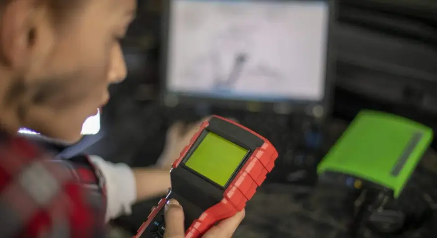 Mechanik z urządzeniem diagnostycznym i laptopem.