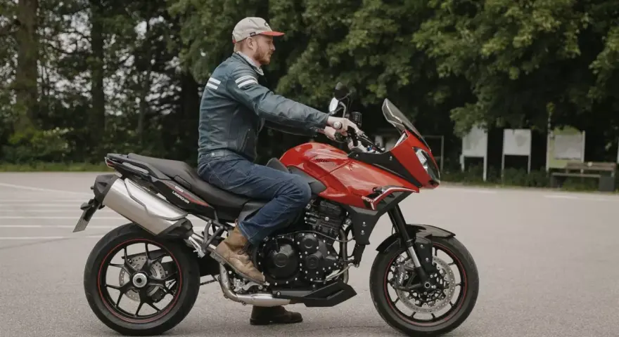 Mężczyzna na czerwonym motocyklu Triumph Tiger 1050. Poznaj jego dane techniczne i możliwości.