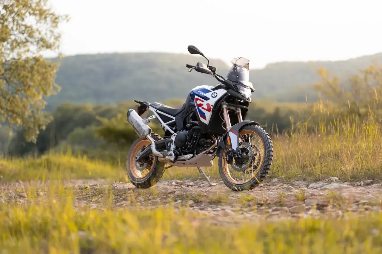 Motocykl BMW F 850 GS Adventure, gotowy na przygodę na leśnej ścieżce.