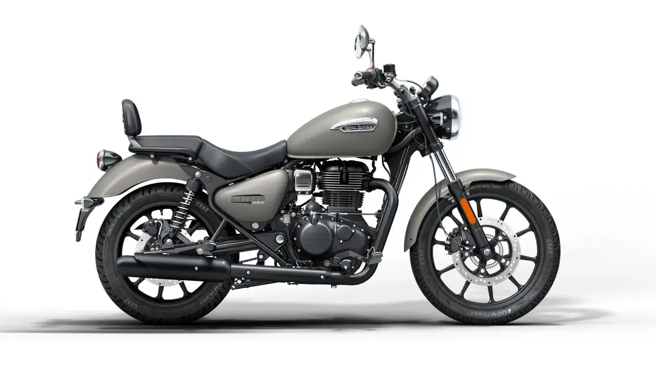 Szary motocykl Royal Enfield Meteor 350 z czarnym siedzeniem i bagażnikiem.