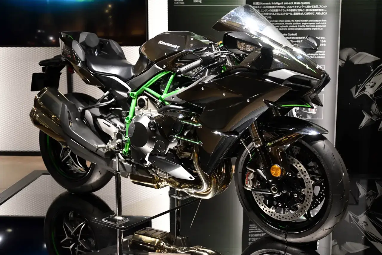 Czarny motocykl Kawasaki H2R z zielonym stelażem, błyszczącymi detalami i sportowym wyglądem.