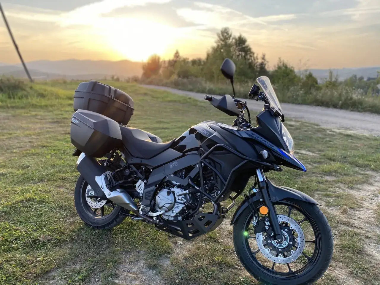 Czarny Suzuki V-Strom 650 z kuframi, gotowy na przygodę. Dane techniczne tego motocykla sprawiają, że jest idealny na długie trasy.