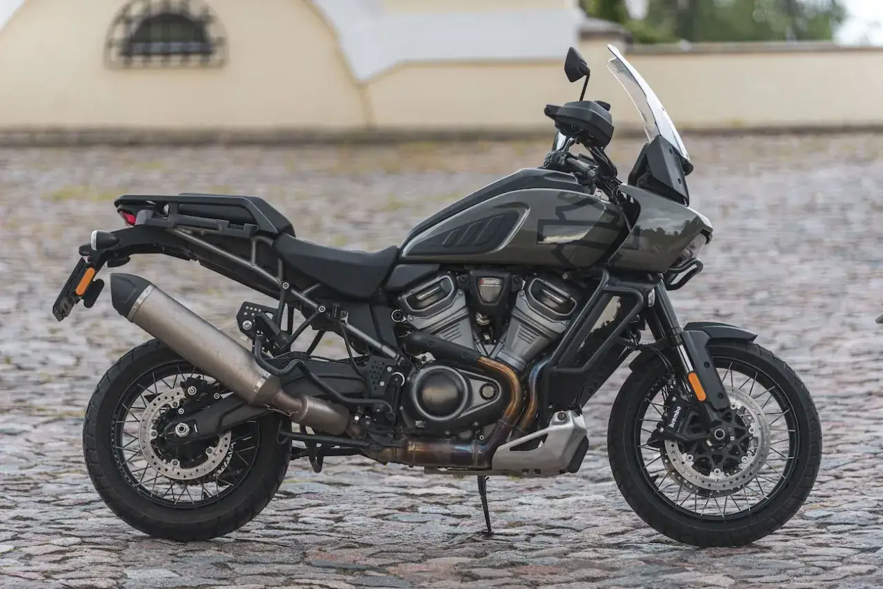 Harley-Davidson Pan America w ciemnozielonym malowaniu, gotowy na przygodę po brukowanej drodze.