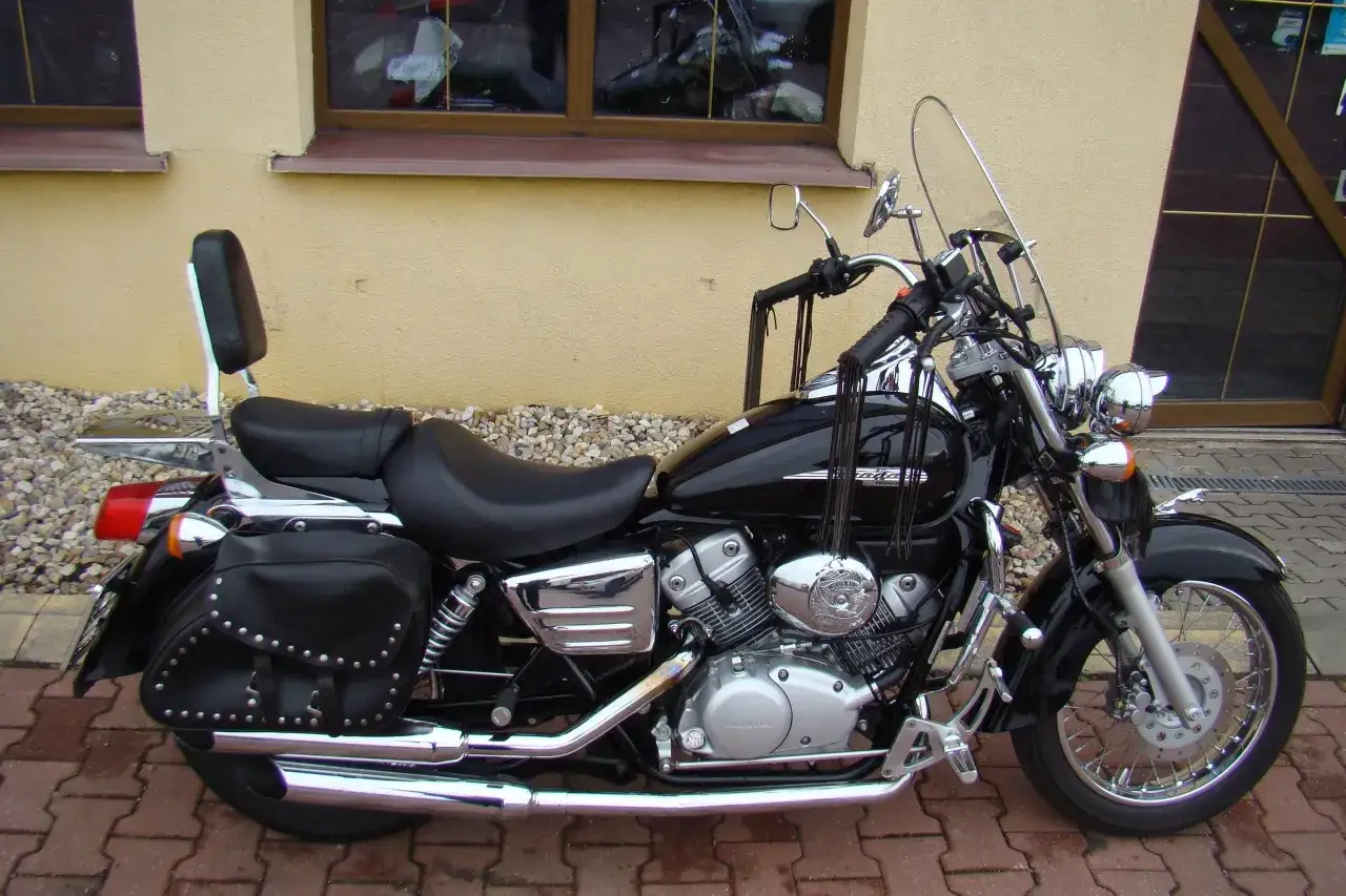 Czarny motocykl Honda Shadow 125, z sakwami i oparciem. Idealny do podróży, sprawdź honda shadow 125 dane techniczne.