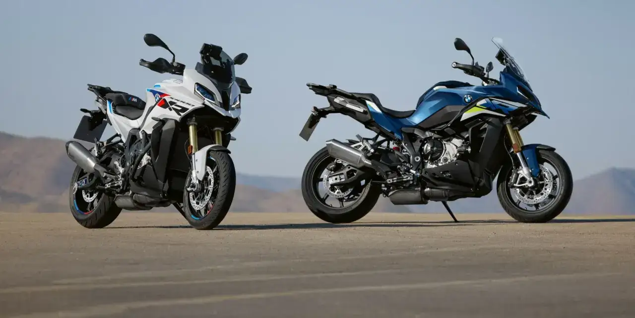 Dwa motocykle BMW S 1000 XR, biały i niebieski, stoją na pustkowiu.