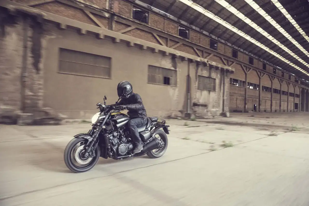Motocyklista w kasku pędzi na swoim V-max przez opuszczony magazyn.