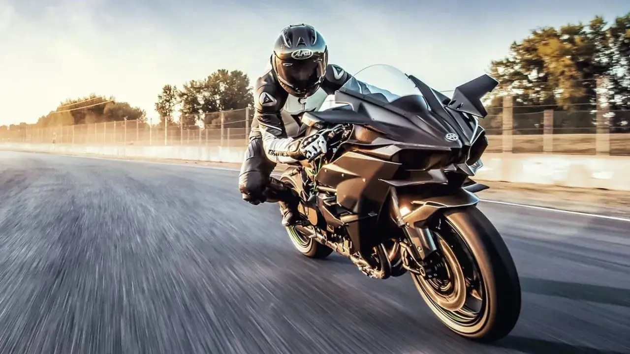 Motocyklista w kombinezonie śmiga na torze na czarnym Kawasaki H2R. Poznaj jego kawasaki h2r dane techniczne.