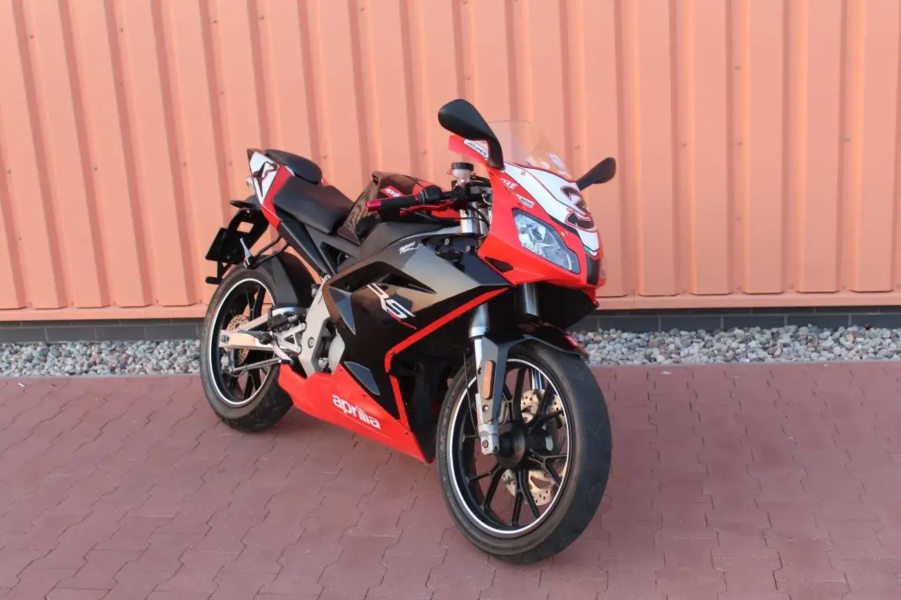 Sportowy motocykl Aprilia RS 50 w czerwono-czarnej kolorystyce, idealny dla młodych pasjonatów. Sprawdź aprilia rs 50 dane techniczne!