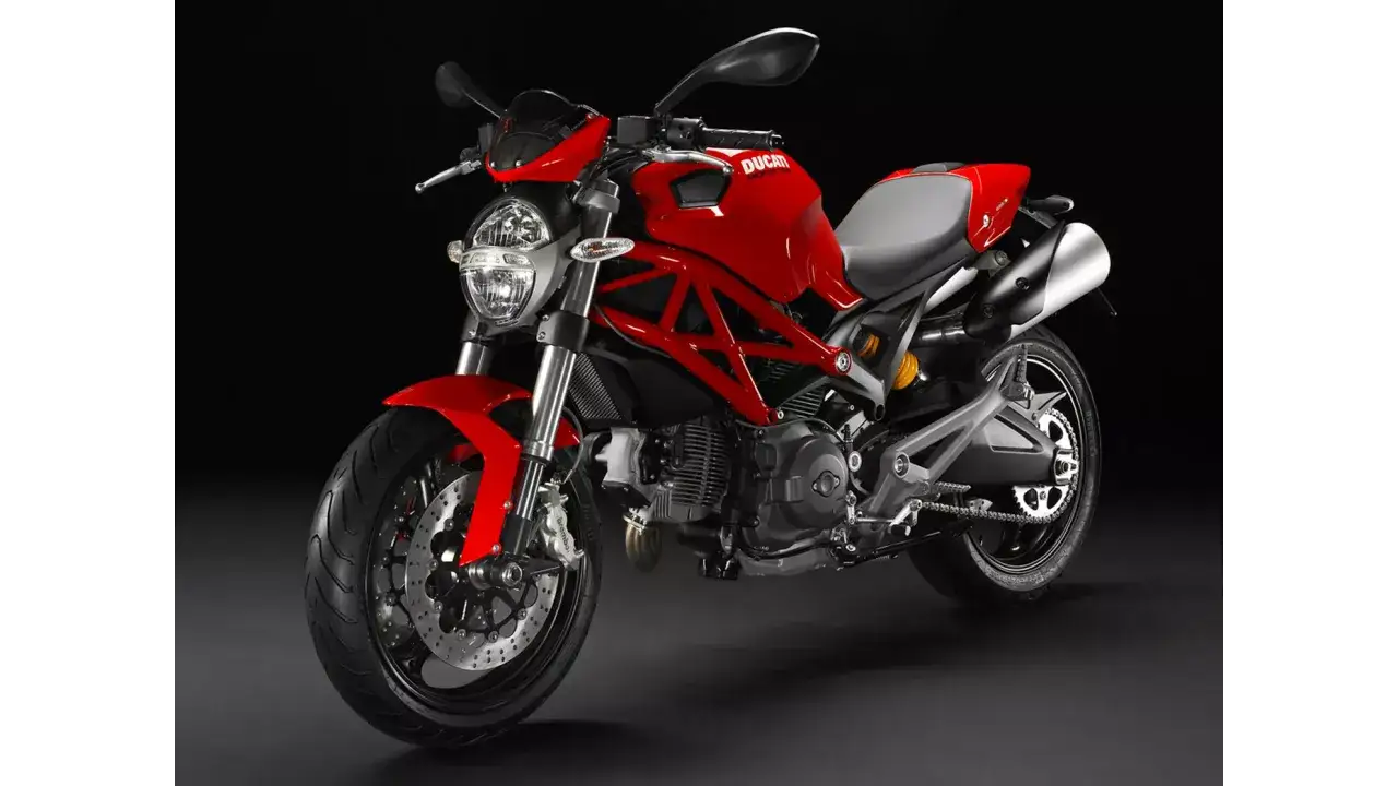 Czerwony Ducati Monster 696 z czarnym stelażem i szarym siedzeniem, gotowy do jazdy.