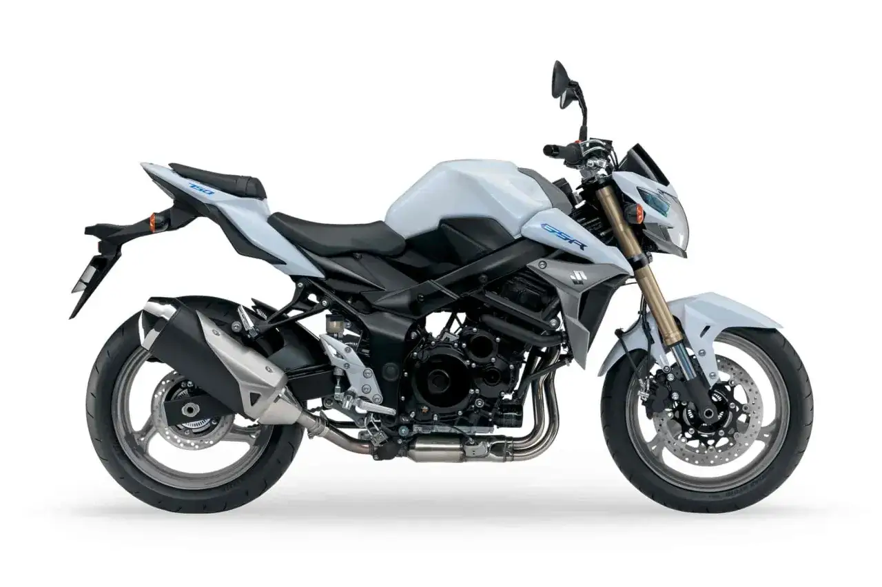 Biały motocykl Suzuki GSR 750, z widocznymi detalami silnika i wydechu. Choć piękny, warto znać jego wady przed zakupem.