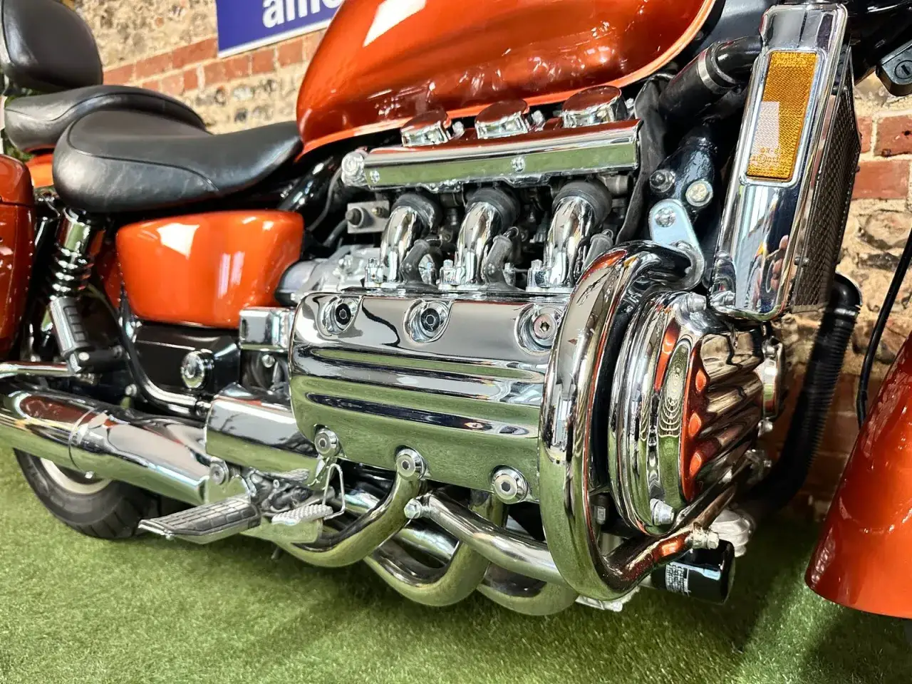Błyszczący, pomarańczowy motocykl Honda Valkyrie 1800 z chromowanym silnikiem.