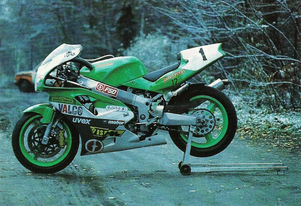 Zielony motocykl wyścigowy Kawasaki ZXR 750 z numerem 1 na tabliczce, gotowy do startu.
