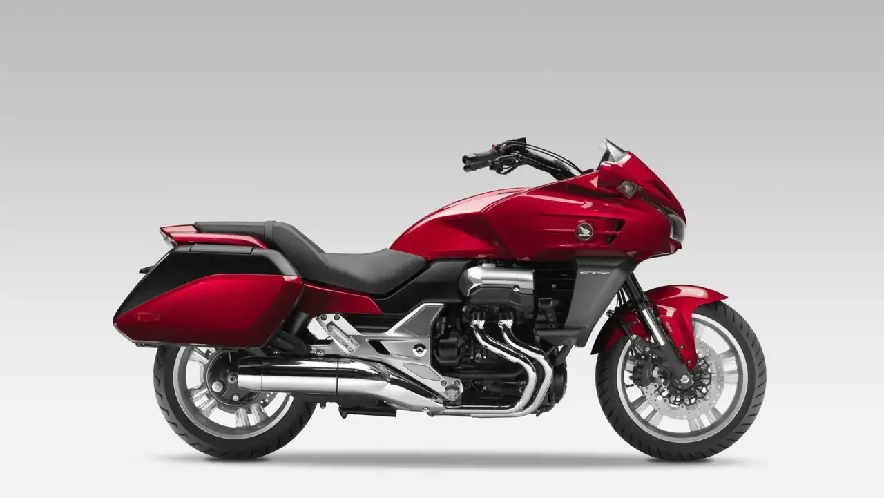 Czerwony motocykl Honda CTX 1300 z sakwami, gotowy na dalekie podróże.