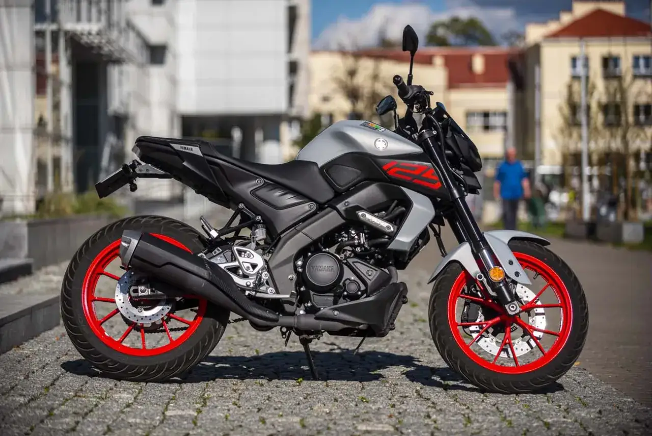 Srebrny Yamaha MT 125 z czerwonymi felgami. Wysokość siedzenia jest idealna dla miejskich podróży.