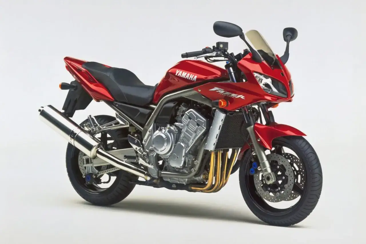 Czerwony motocykl Yamaha Fazer 1000, z widocznymi wężami wydechu i chłodnicą. Niektórzy użytkownicy wskazują na wady tego modelu.