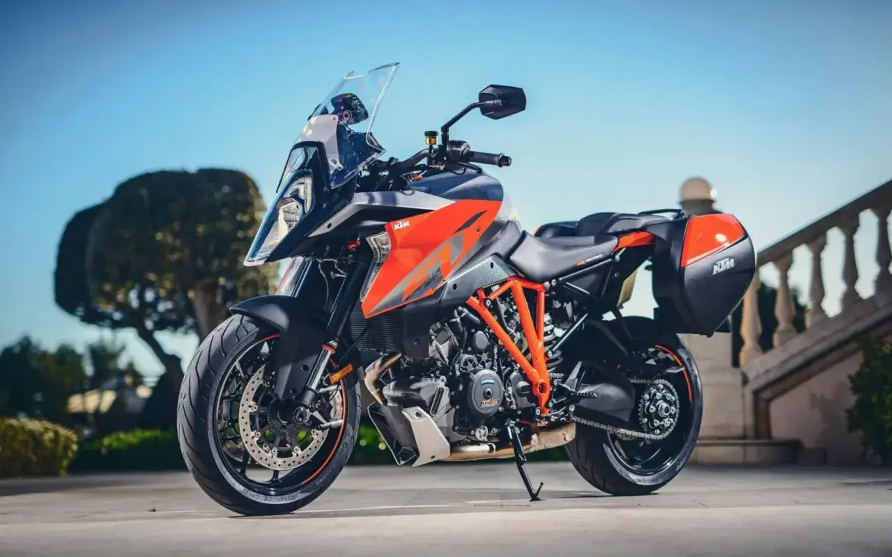 Pomarańczowo-szary KTM 1290 Super Duke GT z kuframi, gotowy na dalekie podróże.