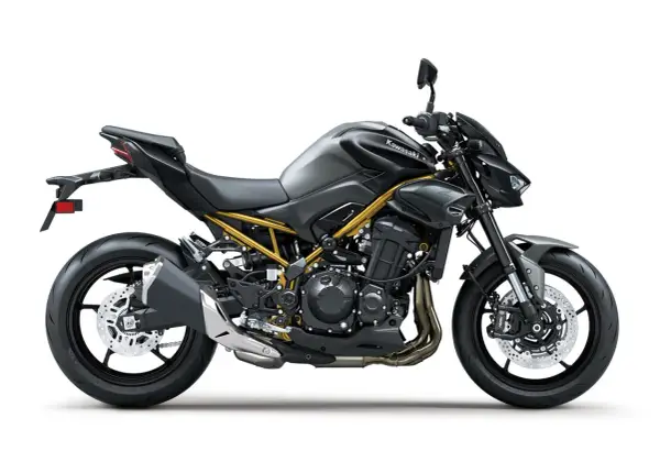 Stylowy, czarny Kawasaki Z900 z widoczną złotą ramą, gotowy na podbój dróg.