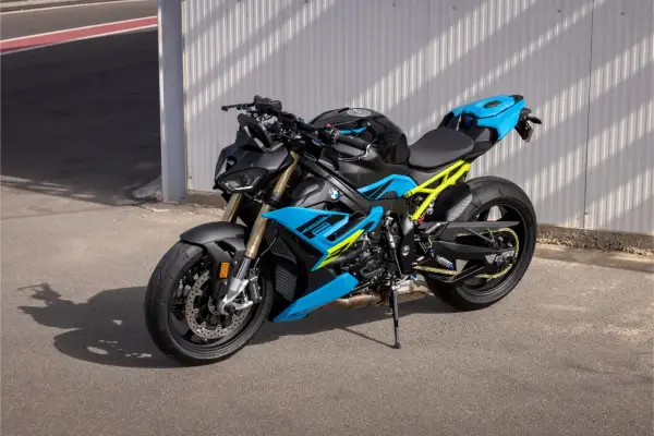 Potężny motocykl BMW S1000R w jaskrawych kolorach niebieskim i żółtym, gotowy do jazdy po torze.