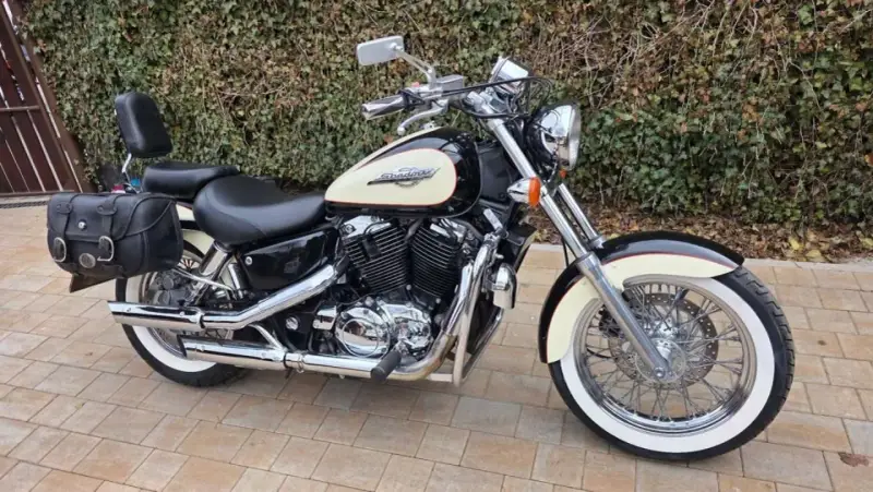 Czarny motocykl Honda Shadow 1100 z kremowym bakiem i sakwami. Idealny na długie trasy, sprawdź honda shadow 1100 dane techniczne.